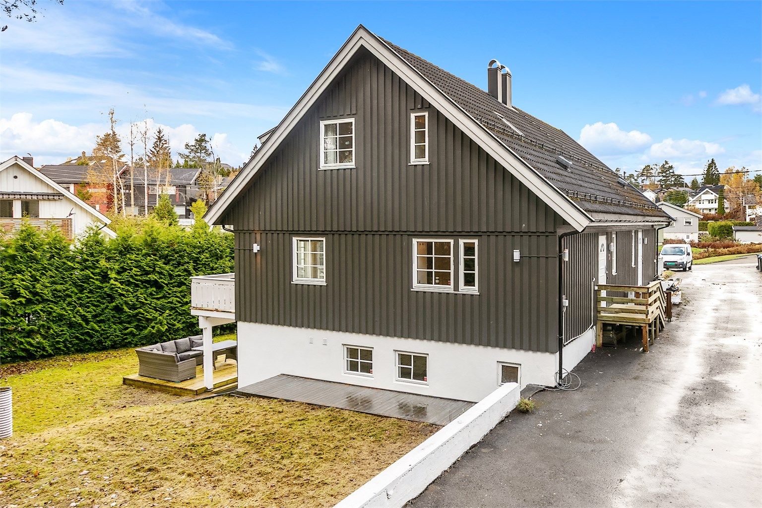 Asfaltert adkomstvei og gårdsplass samt en stor hage med hekk som gir lite innsyn. 