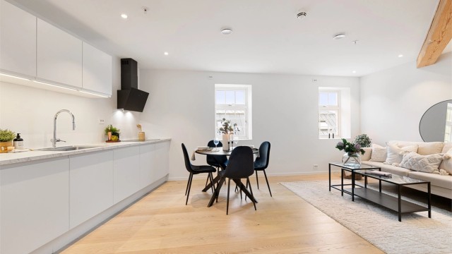 Første etasje har en åpen løsning mellom stue og kjøkken, et sosialt rom med plass til både sofagruppe og spisebord.