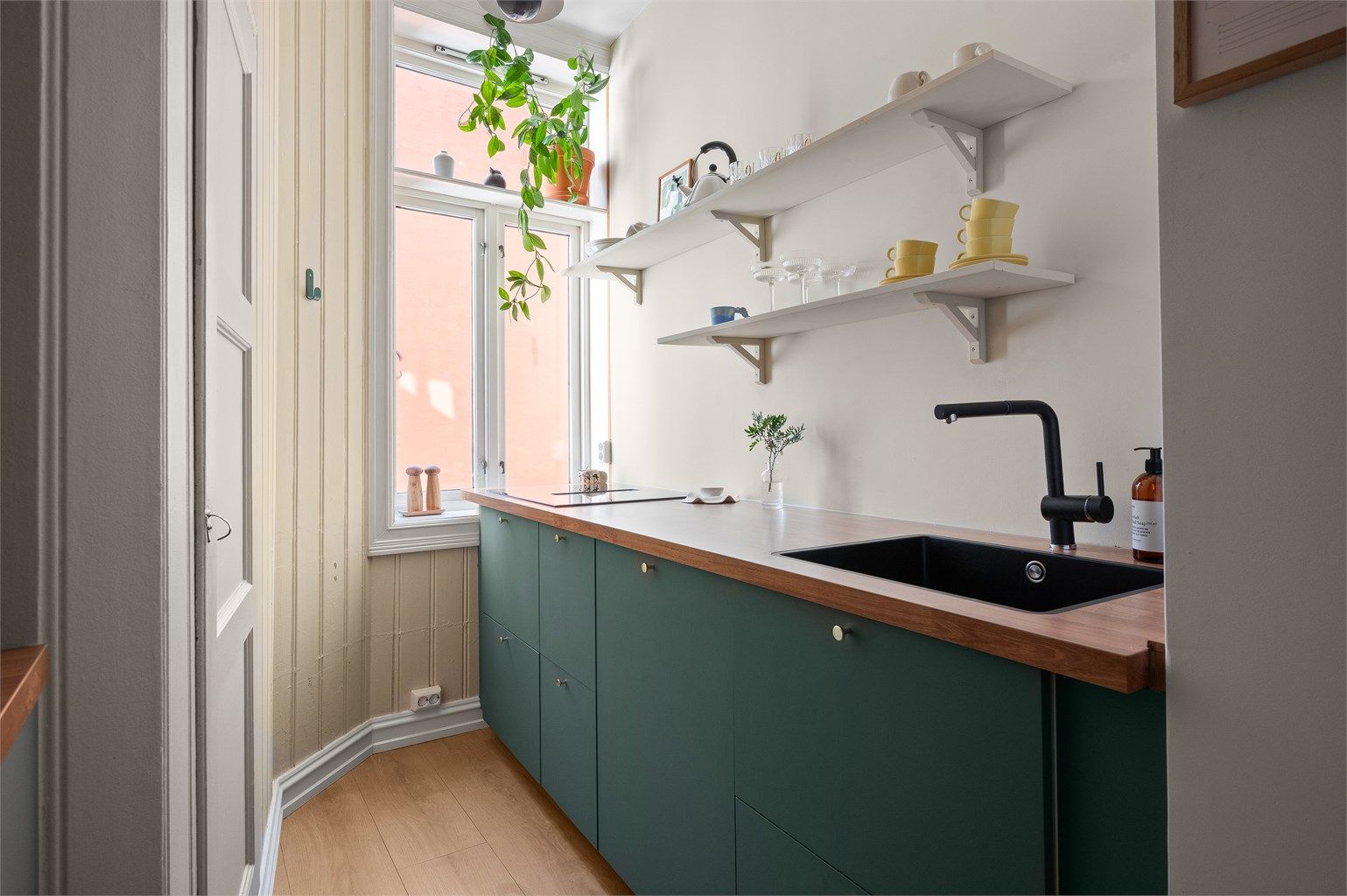 Laminatbenkeplate med planlimt vaskekum, integrert induksjonstopp og oppvaskmaskin.