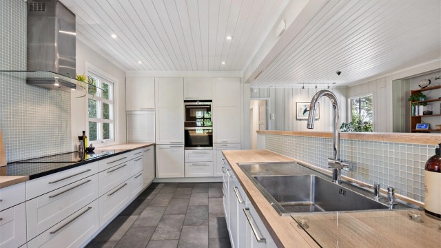 Integrerte hvitevarer og flislagt gulv.