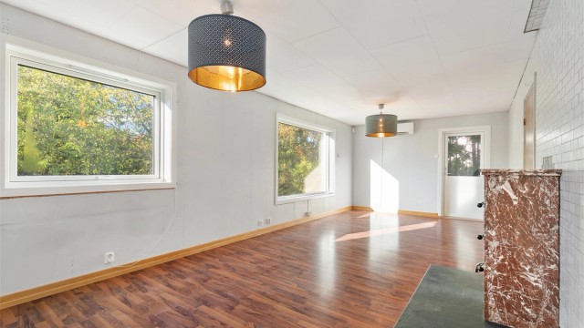 Stuen har peisovn og varmepumpe, og leder direkte ut til terrassen.
Foto: Hanne Bruland/FotoHanne