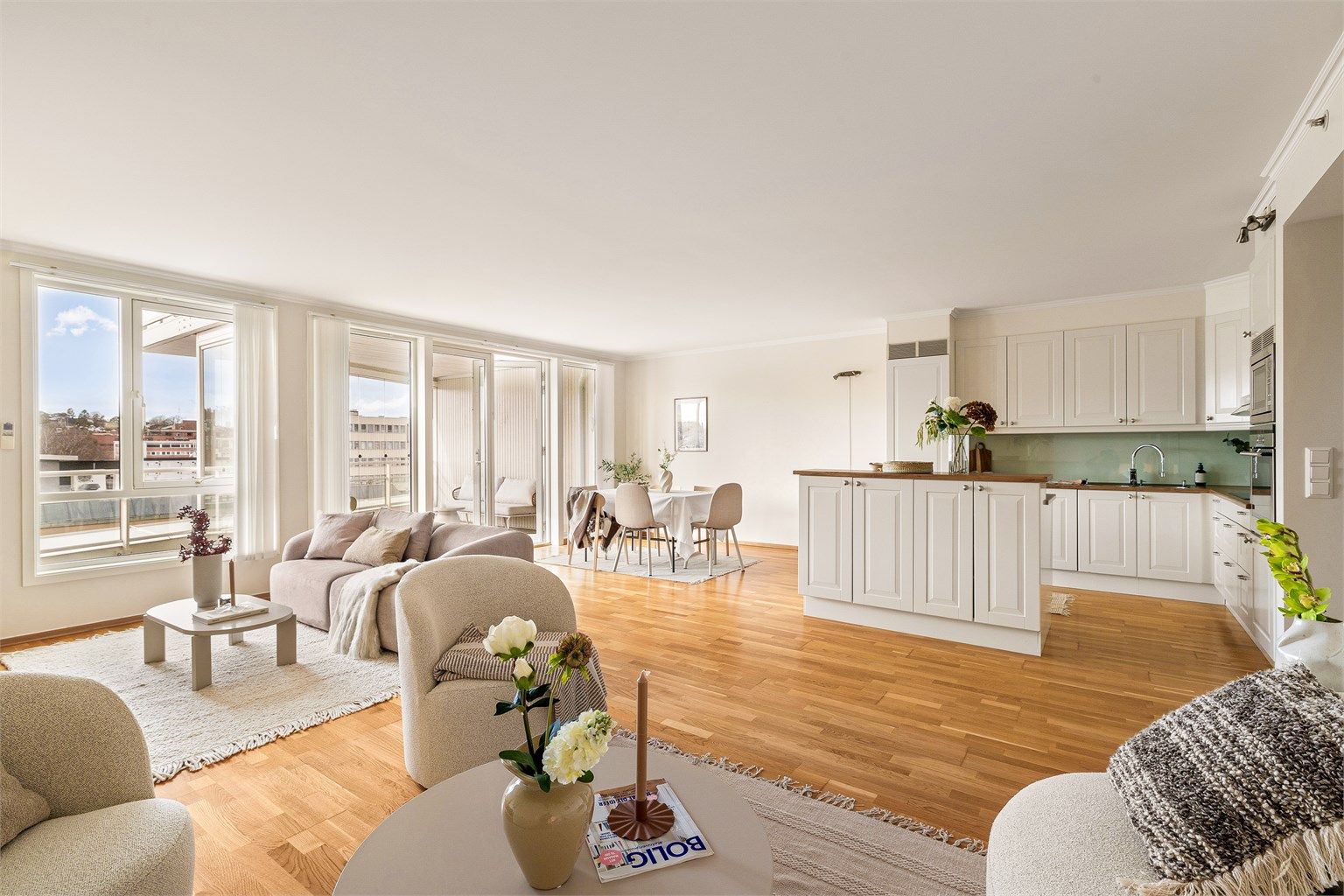 En åpen og sosial planløsning mellom stue og kjøkken gir en luftig romfølelse. Gulvene har gjennomgående parkett.