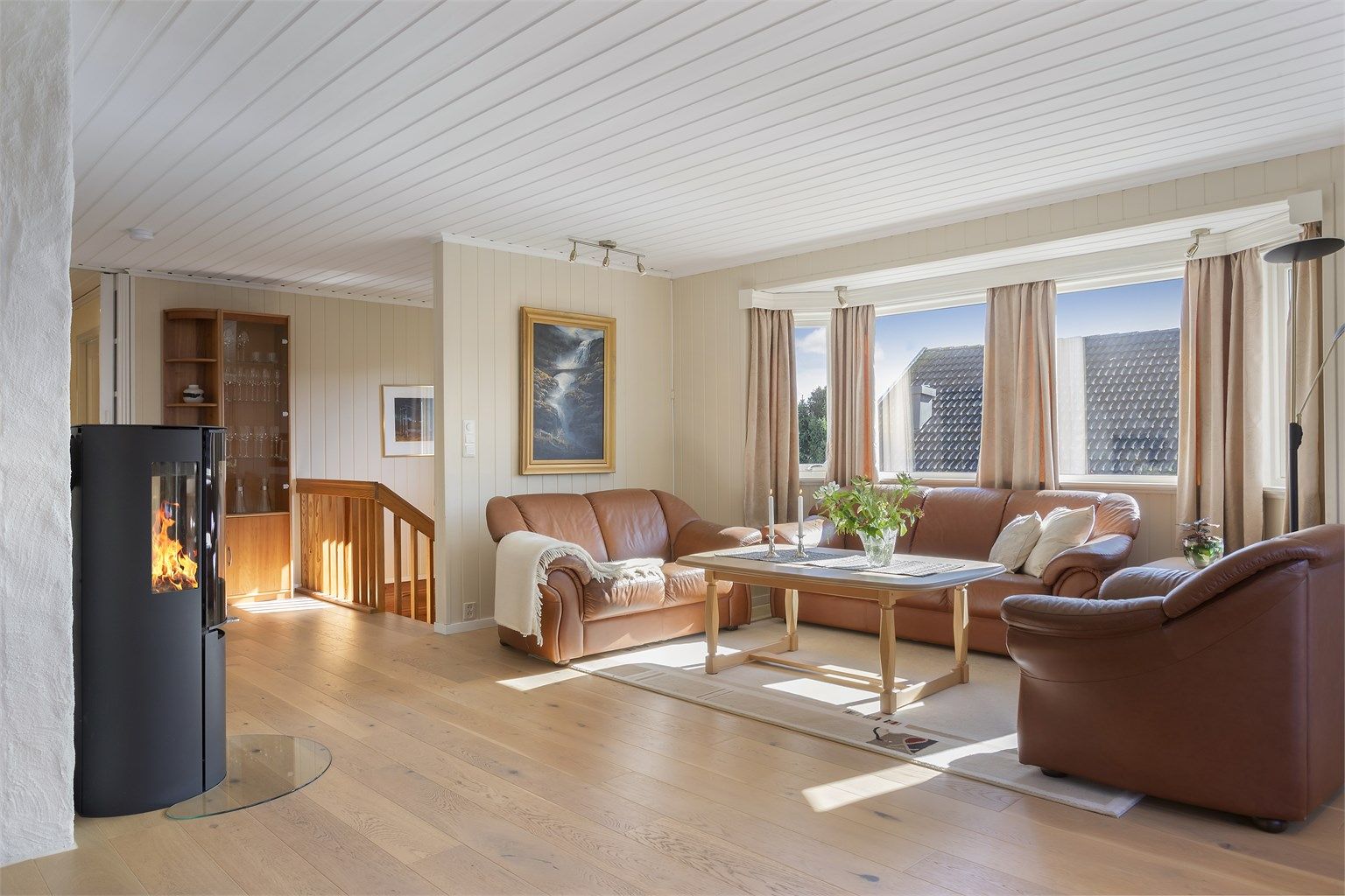 Resten av stuen har god plass til sofagruppe rundt den sentralt plasserte peisovnen fra 2019.