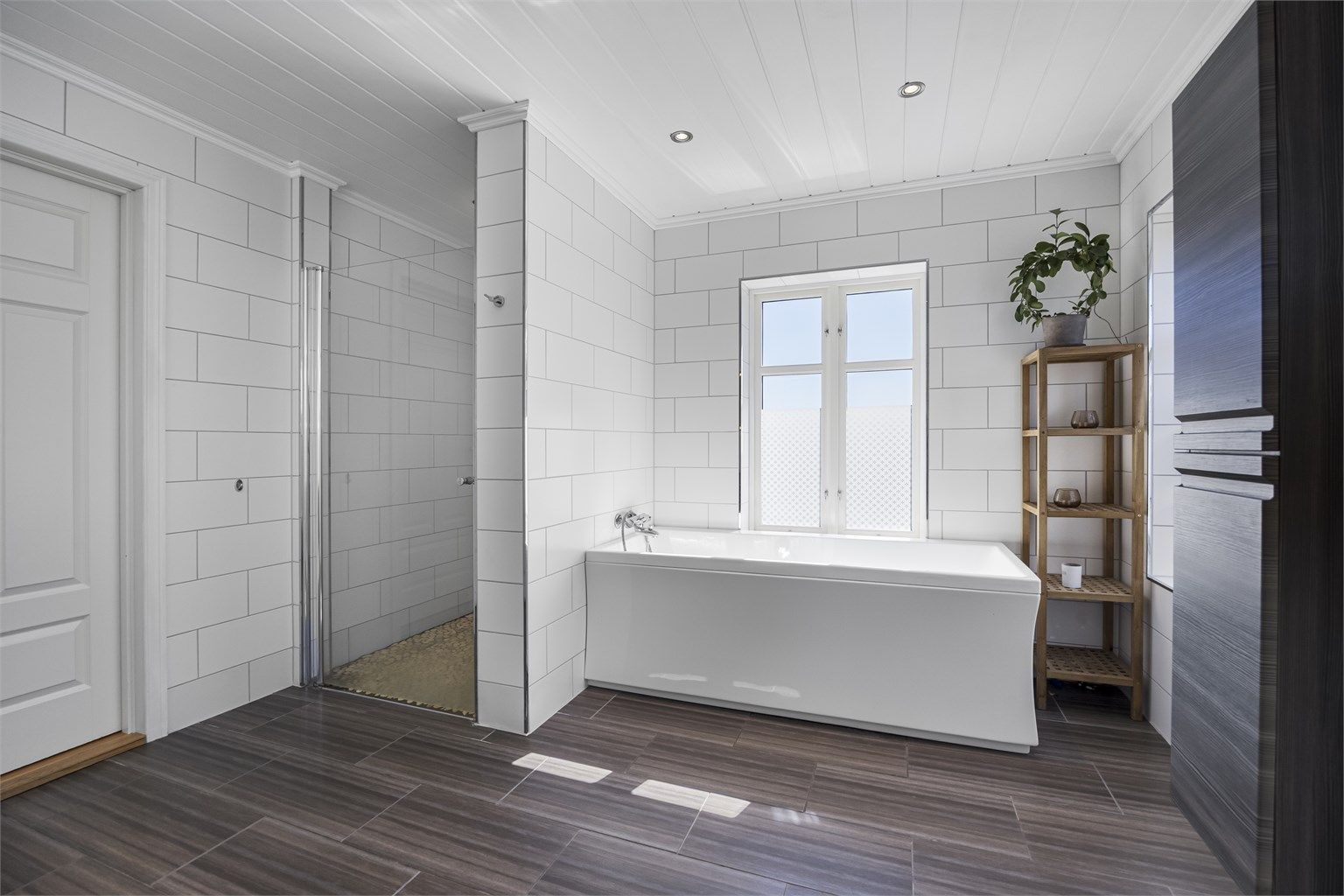 Badet er utstyrt med både dusjhjørne og et badekar for ekstra komfort.