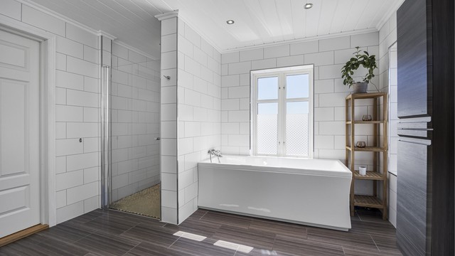 Badet er utstyrt med både dusjhjørne og et badekar for ekstra komfort.