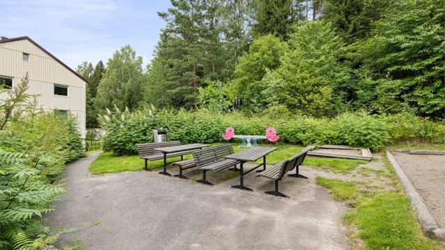 På siden av den øverste blokken er det satt ut sittegruppe som innbyr til grilling, mens barna sparkesykler eller hopper paradis