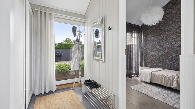 Velkommen inn i en romslig entré med god plass til å henge fra deg yttertøyet i skyvedørsgarderobe.