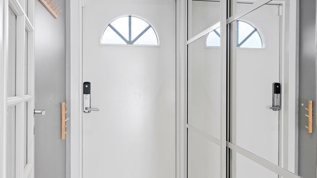 Entréen har flislagt gulv med varmekabler og en romslig skyvedørsgarderobe med speilfronter.
