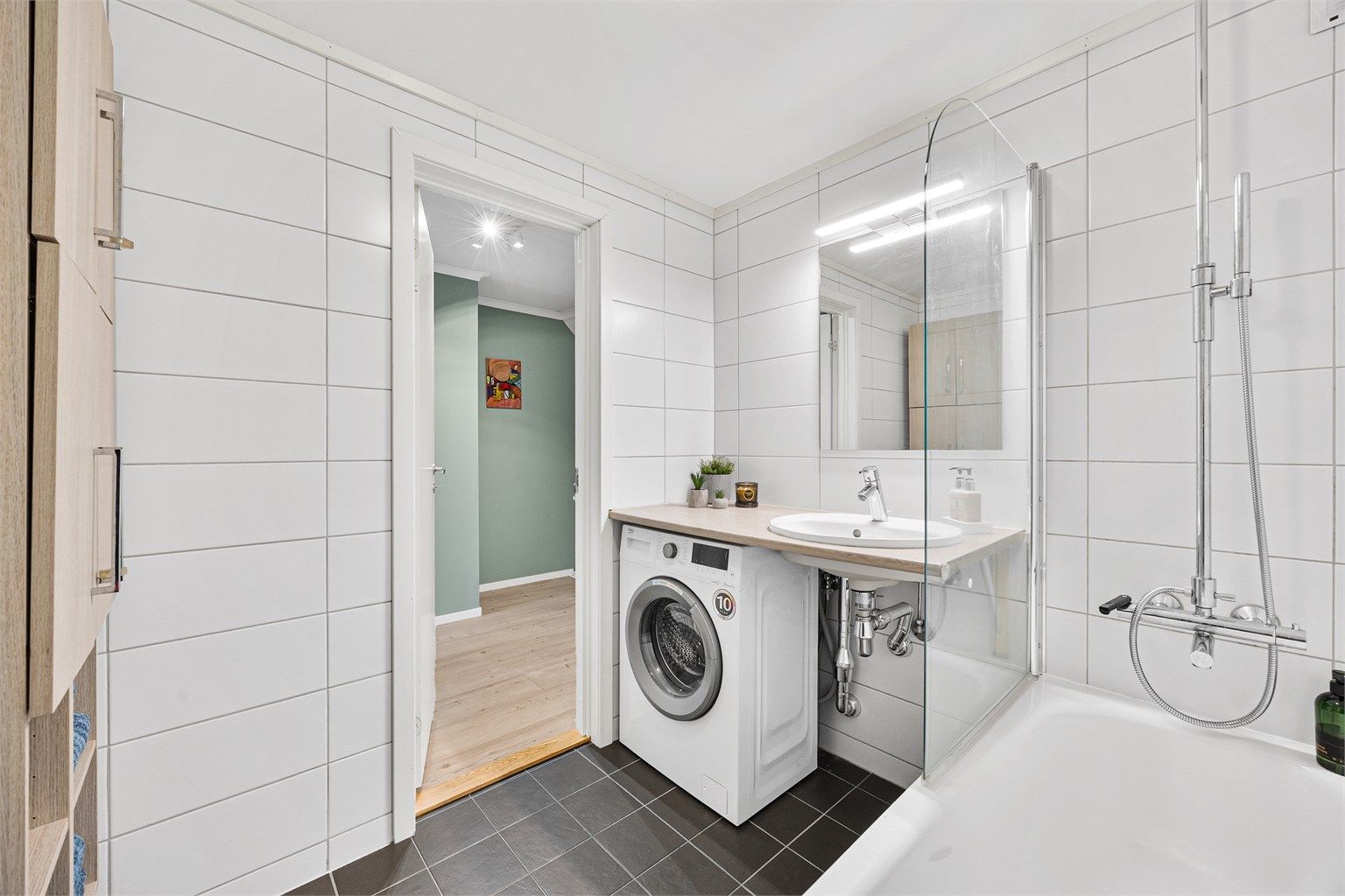 Baderomsinnredning med servant og veggskap gir praktisk oppbevaring.