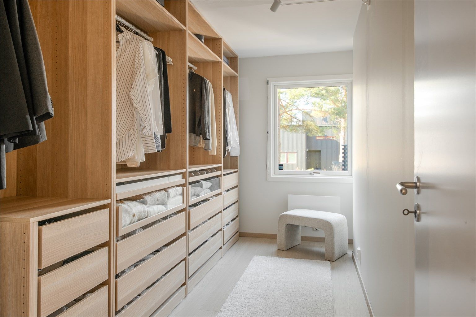 Et av rommene er innredet som en romslig walk-in-garderobe med skreddersydd innredning.