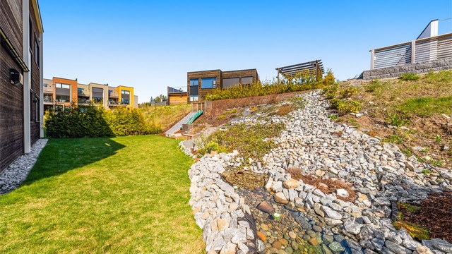 På baksiden av boligen kan de med grønne fingre holde det gående med diverse beplantning. Det er også innlagt dam i hagen.