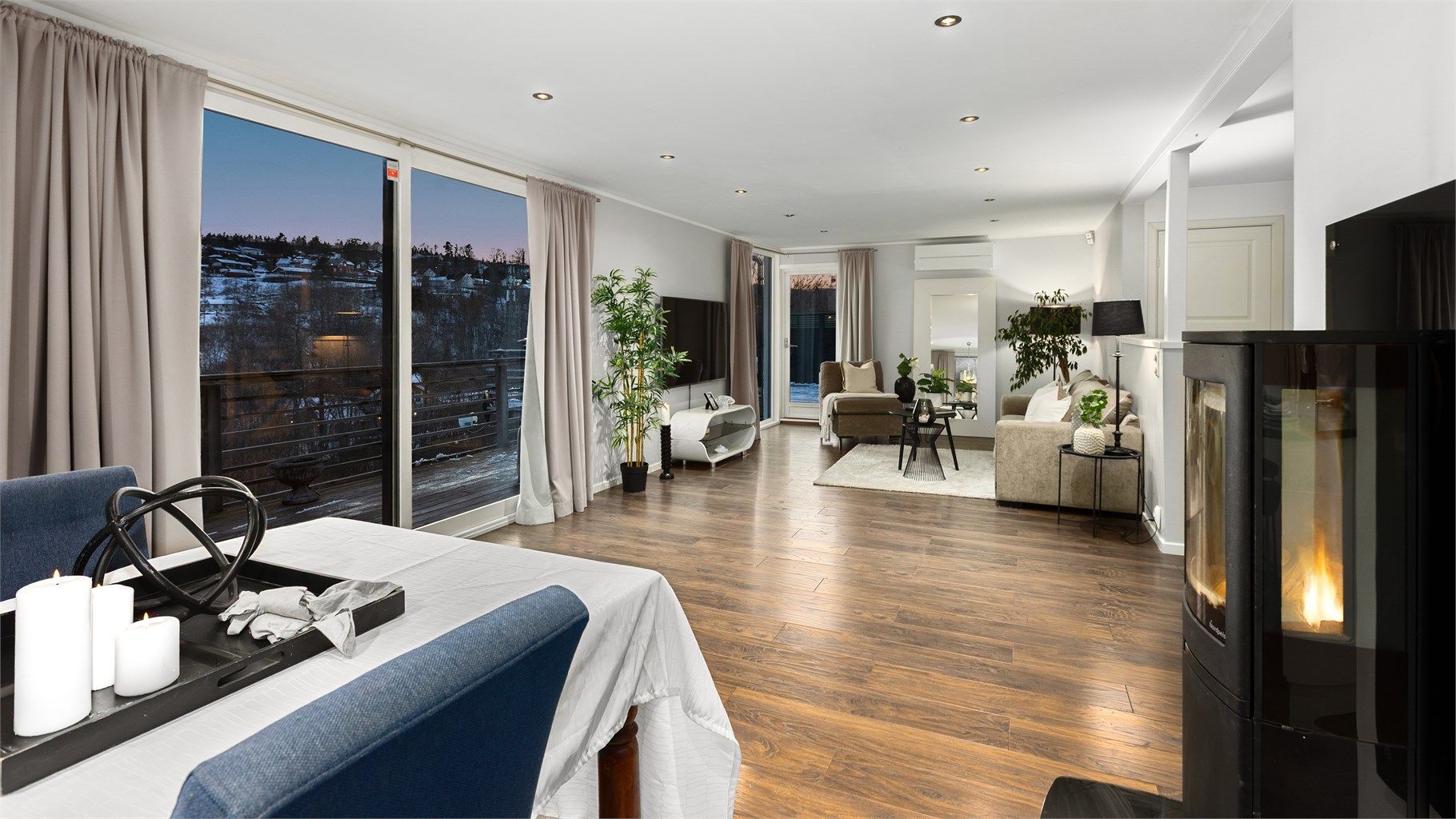 Boligen har en åpen og luftig planløsning mellom stue og kjøkken. her er det store vindusflater som sikrer mye naturlig lys inn i rommet