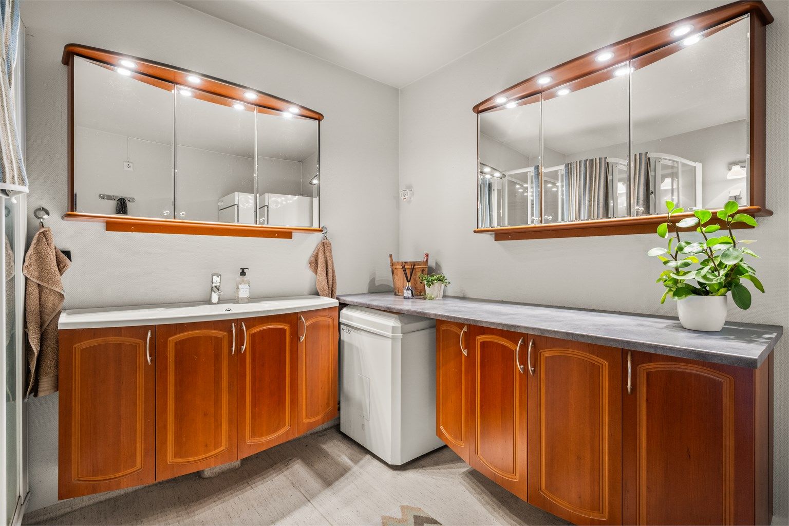 Baderomsinnredningen gir rikelig med oppbevaringsplass i både benkeskap og speilskap.