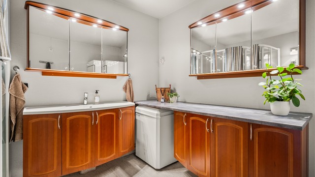 Baderomsinnredningen gir rikelig med oppbevaringsplass i både benkeskap og speilskap.