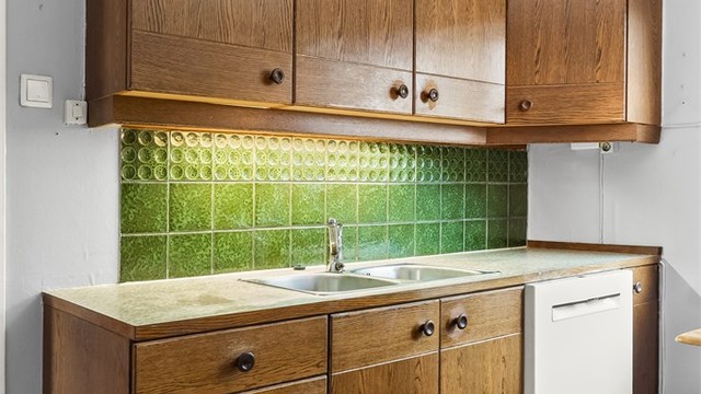 Kjøkkeninnredning fra ca. 1978 med glatte fronter og laminert benkeplate.