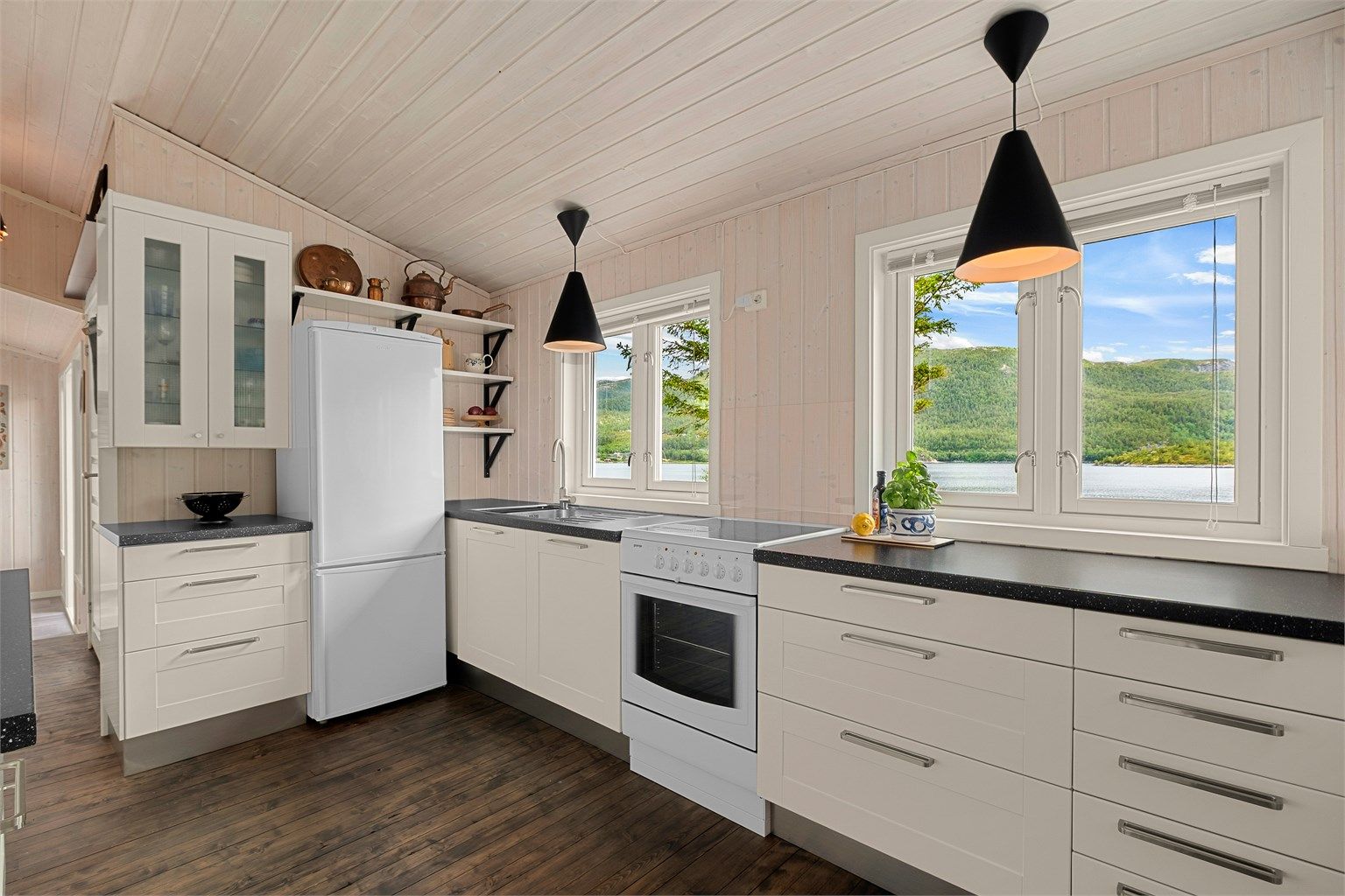 Kjøkkenet hvor vinduene gir flott utsikt mot sjø og omkringliggende natur.