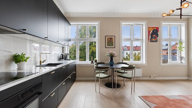 Åpen løsning mellom stue og kjøkken gir rikelig med naturlig lys og plass til spisebord.