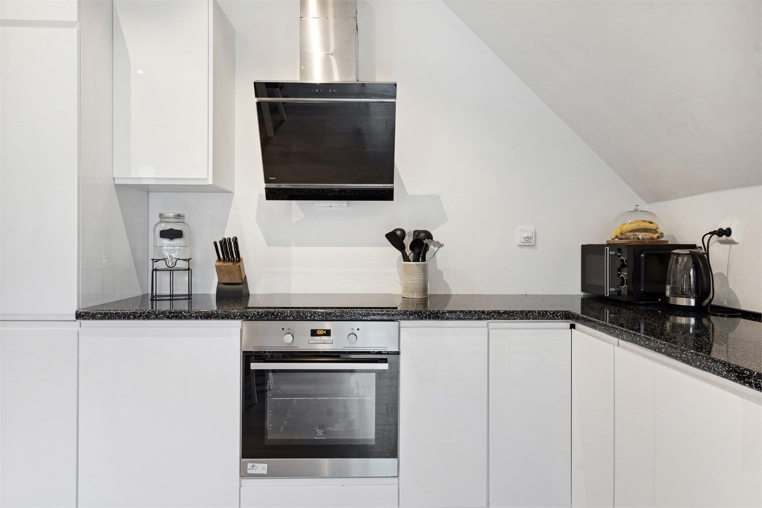 Kjøkkenet på loft har innredning med hvite glatte fronter. Benkeplaten er av laminat. Det er integrert kjøleskap, fryseskap, oppvaskmaskin, induksjonstopp og stekeovn. Det er montert komfyrvakt. Det er kjøkkenventilator med avtrekk ut.