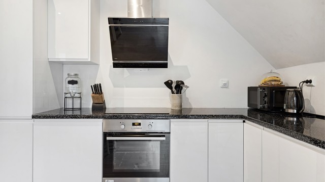 Kjøkkenet på loft har innredning med hvite glatte fronter. Benkeplaten er av laminat. Det er integrert kjøleskap, fryseskap, oppvaskmaskin, induksjonstopp og stekeovn. Det er montert komfyrvakt. Det er kjøkkenventilator med avtrekk ut.