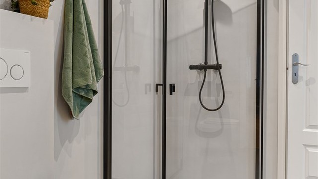 Lekker dusjsone med plassbesparende, glassvegger med sort innramming, som står godt i stil med dusjopplegget