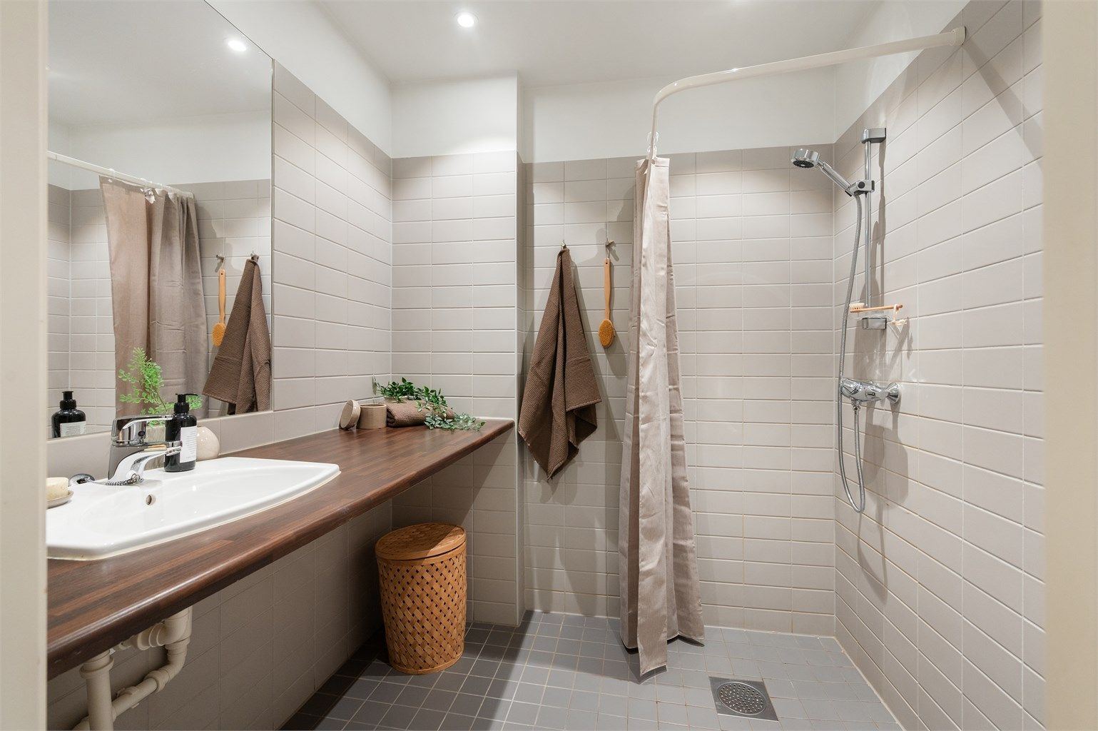 Leilighetens bad er romslig og delikat. Rommet er tidløst flislagt og ble rehabilitert samtidig som dette historiske bygget ble omgjort fra fabrikk til leiligheter i 2005. Det er opplegg for vaskemaskin.