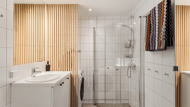 Flislagt og delikat bad med behagelig gulvvarme, dusjhjørne og opplegg for vaskemaskin.