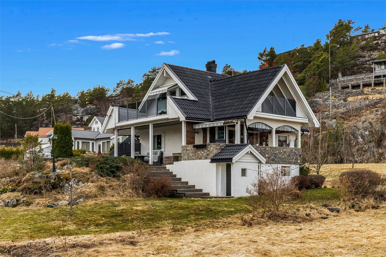 Huset har rikelig med uteplasser og en original kulesteins omramming av terrassen.