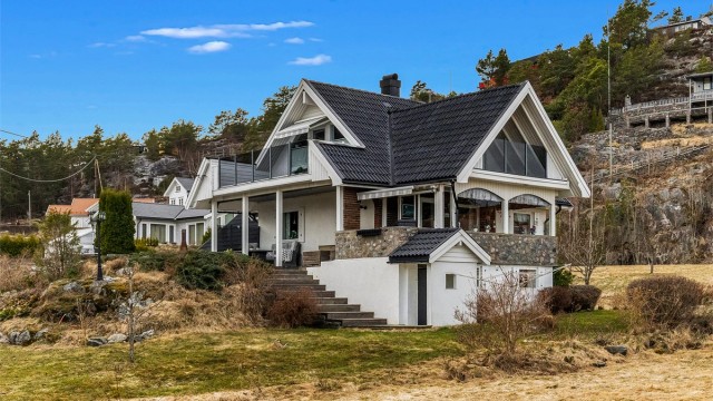 Huset har rikelig med uteplasser og en original kulesteins omramming av terrassen.