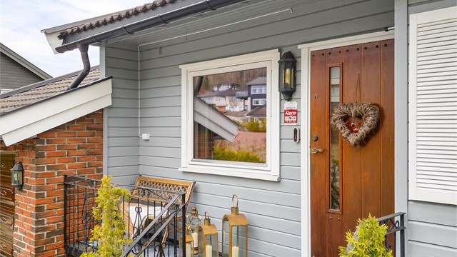 Inngangspartiet har en trapp i metallkonstruksjon og en ytterdør med glassfelt.