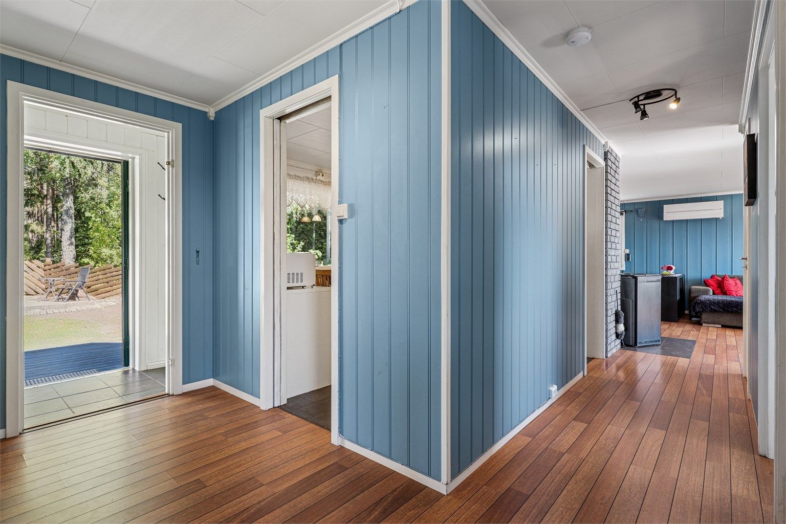 I hovedetasjen møter vi først entréen med plass til å henge fra seg yttertøy og deretter videre inn til en romslig gang.