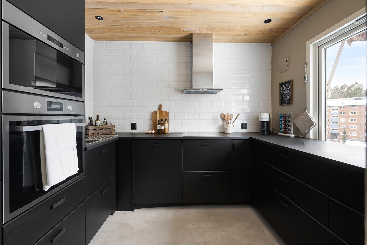 Lekkert IKEA-kjøkken fra 2020. Moderne innredning med glatte, sorte fronter. Det er rikelig med benkeplass som gjør matlagingen enkel. 