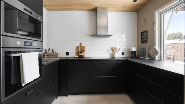 Lekkert IKEA-kjøkken fra 2020. Moderne innredning med glatte, sorte fronter. Det er rikelig med benkeplass som gjør matlagingen enkel.