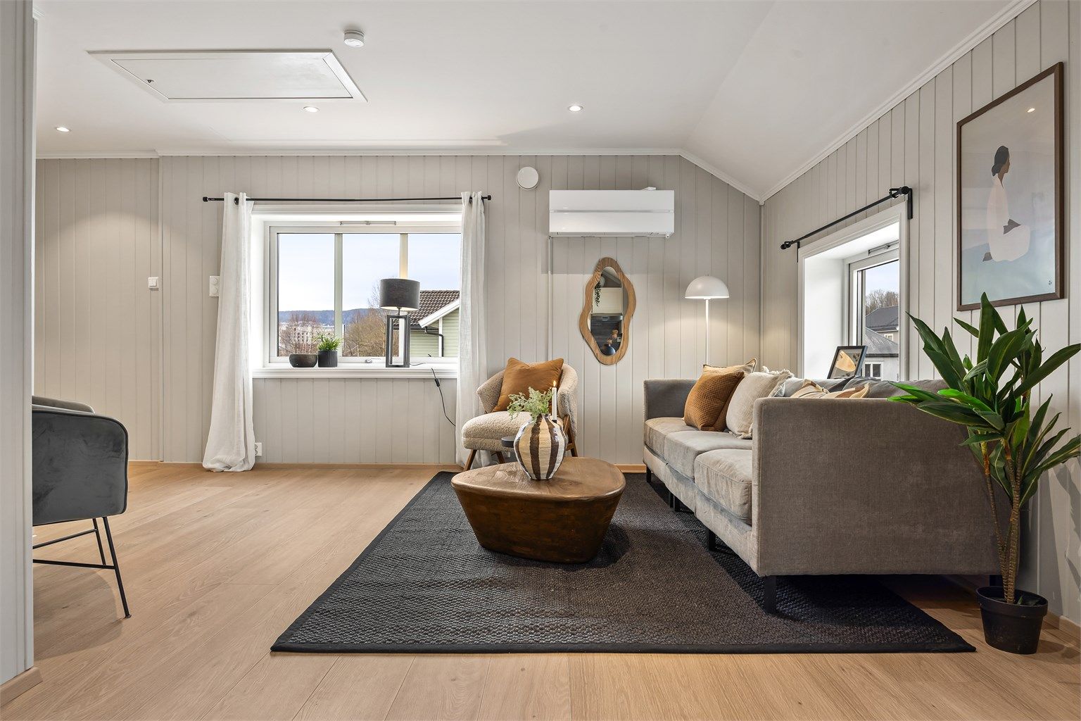 Åpen kjøkken- og stueløsning med sofaområde samt spiseplass.