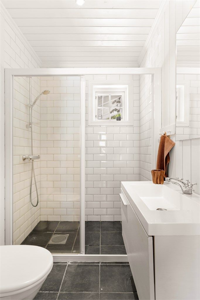 Badet i gjesteavdelingen har flislagt gulv med gulvvarme og dusjhjørne med glassvegger.
