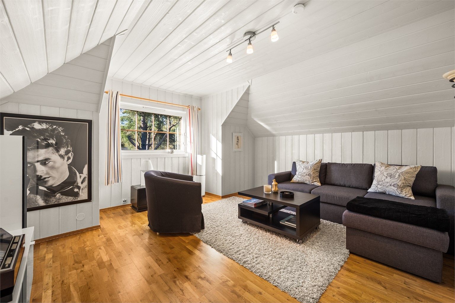 Loftsetasjen har to gode soverom. Dette rommet har parkettgulv og malt panel.