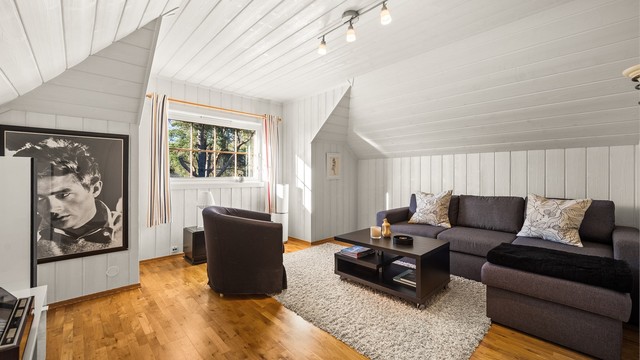 Loftsetasjen har to gode soverom. Dette rommet har parkettgulv og malt panel.
