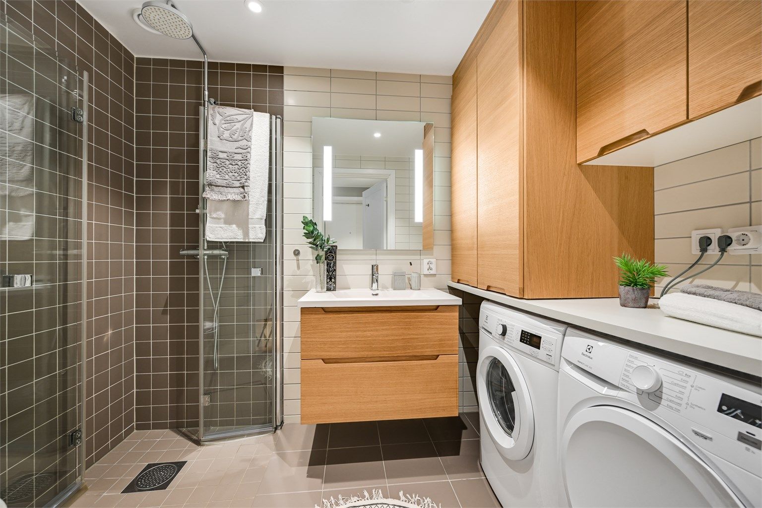 Badet er av god størrelse og har pene fliser på vegger og varmekabler i gulvet.