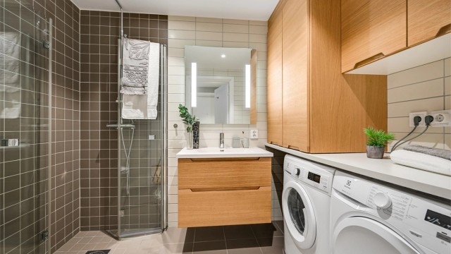 Badet er av god størrelse og har pene fliser på vegger og varmekabler i gulvet.