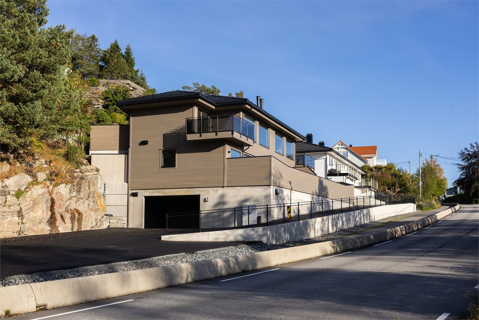 Nyoppført leilighet/ tomannsbolig med moderne arkitektur og integrert garasjeanlegg i sokkelen.