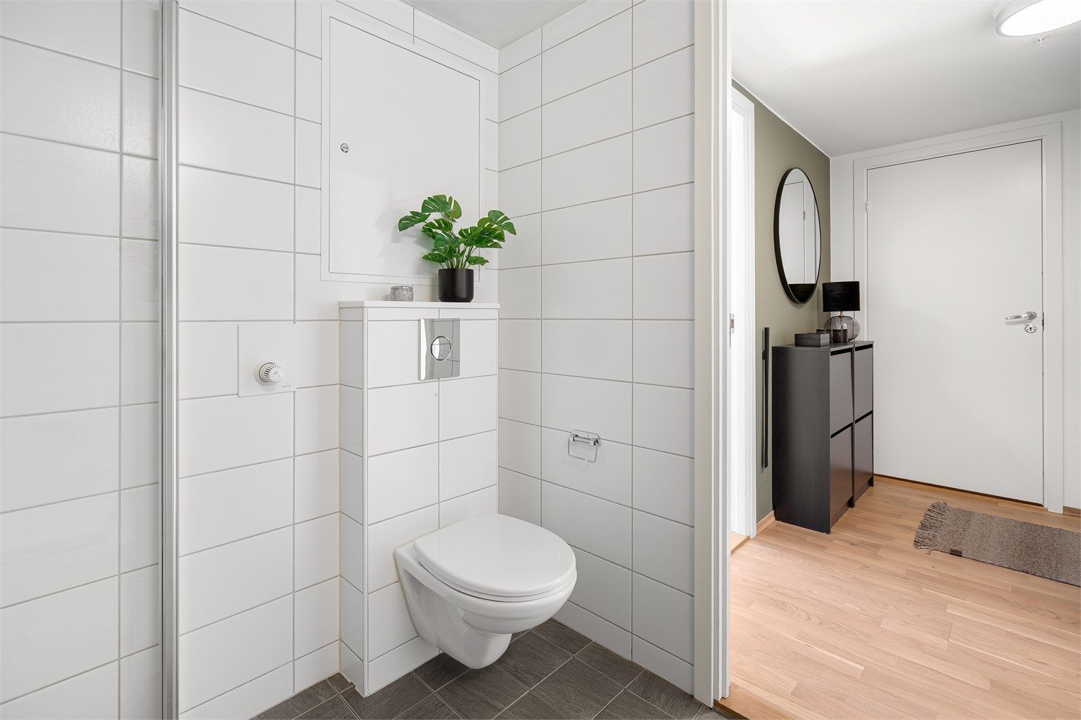 Badet er utstyrt med vegghengt servantinnredning, ovenpåliggende servant med armatur, vegghengt toalett , speil med overlys og stikkontakt over servant.