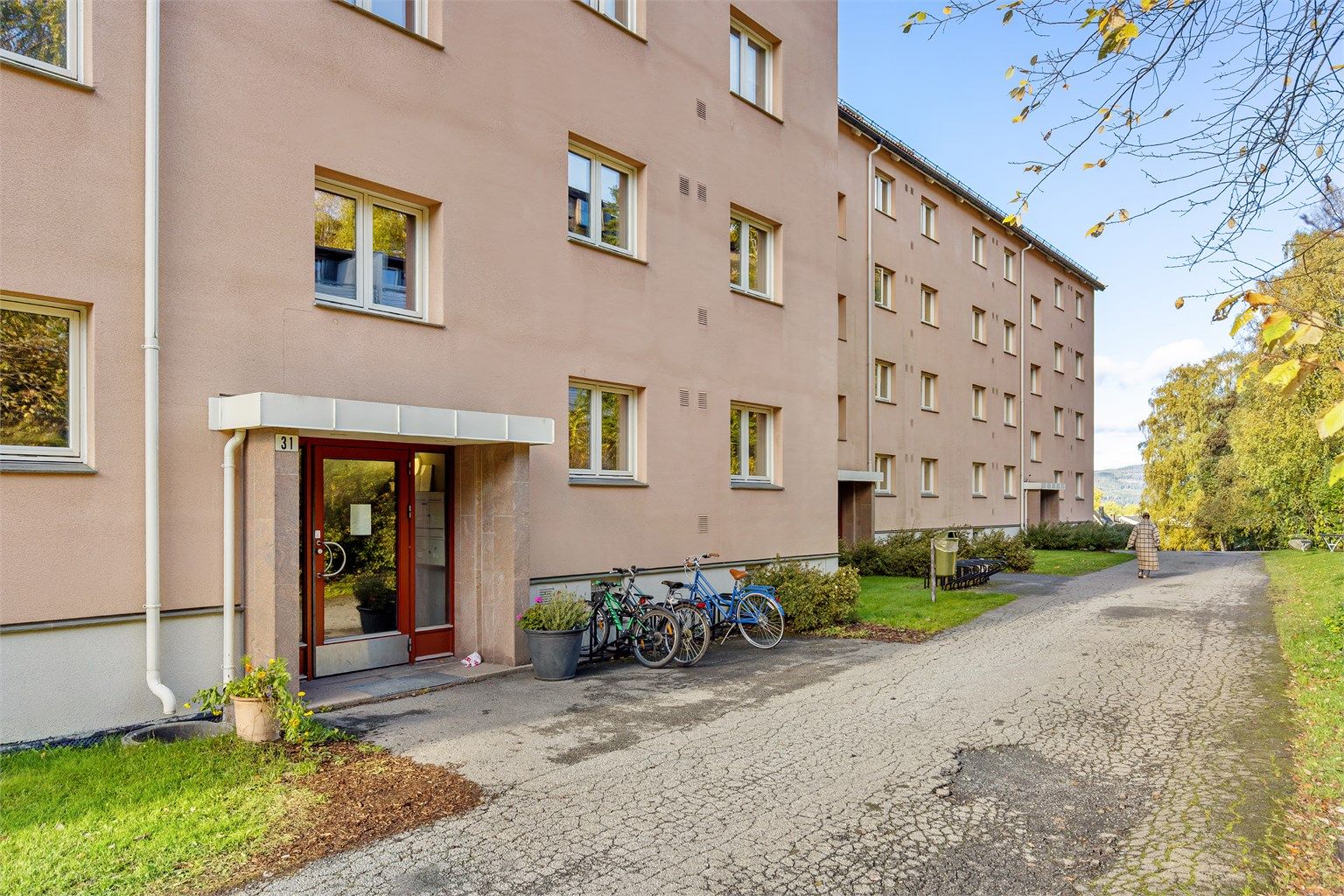 Inngangsparti til Kurveien 31 med asfaltert adkomst og sykkelparkering.
