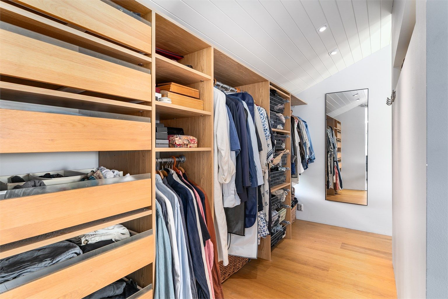 Hovedsoverommets garderobe/walk-in closet er tilgjengelig fra begge sider av dobbeltsengen.