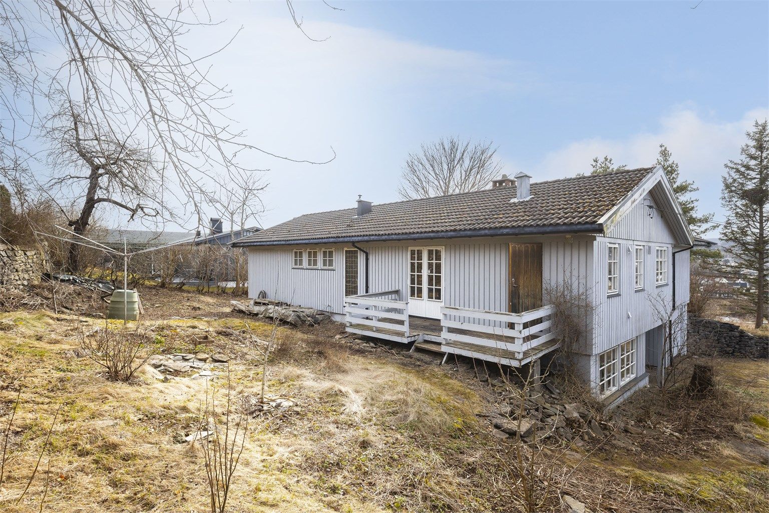 Eldre veranda på utsiden av kjøkken og spisestue, hvor man kan nyte morgensolen.