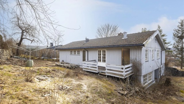 Eldre veranda på utsiden av kjøkken og spisestue, hvor man kan nyte morgensolen.