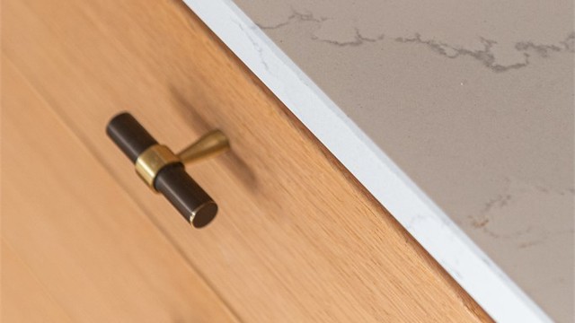 Solide skuffeseksjoner med detaljerte beslag og benkeplate av stein.