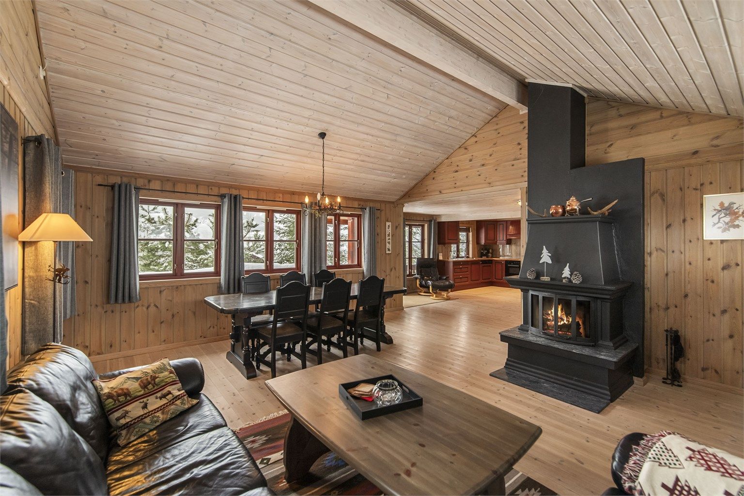 Det sosiale samlingspunktet er stuen, med god takhøyde, heltrebord på gulv og panel på vegger og i tak.