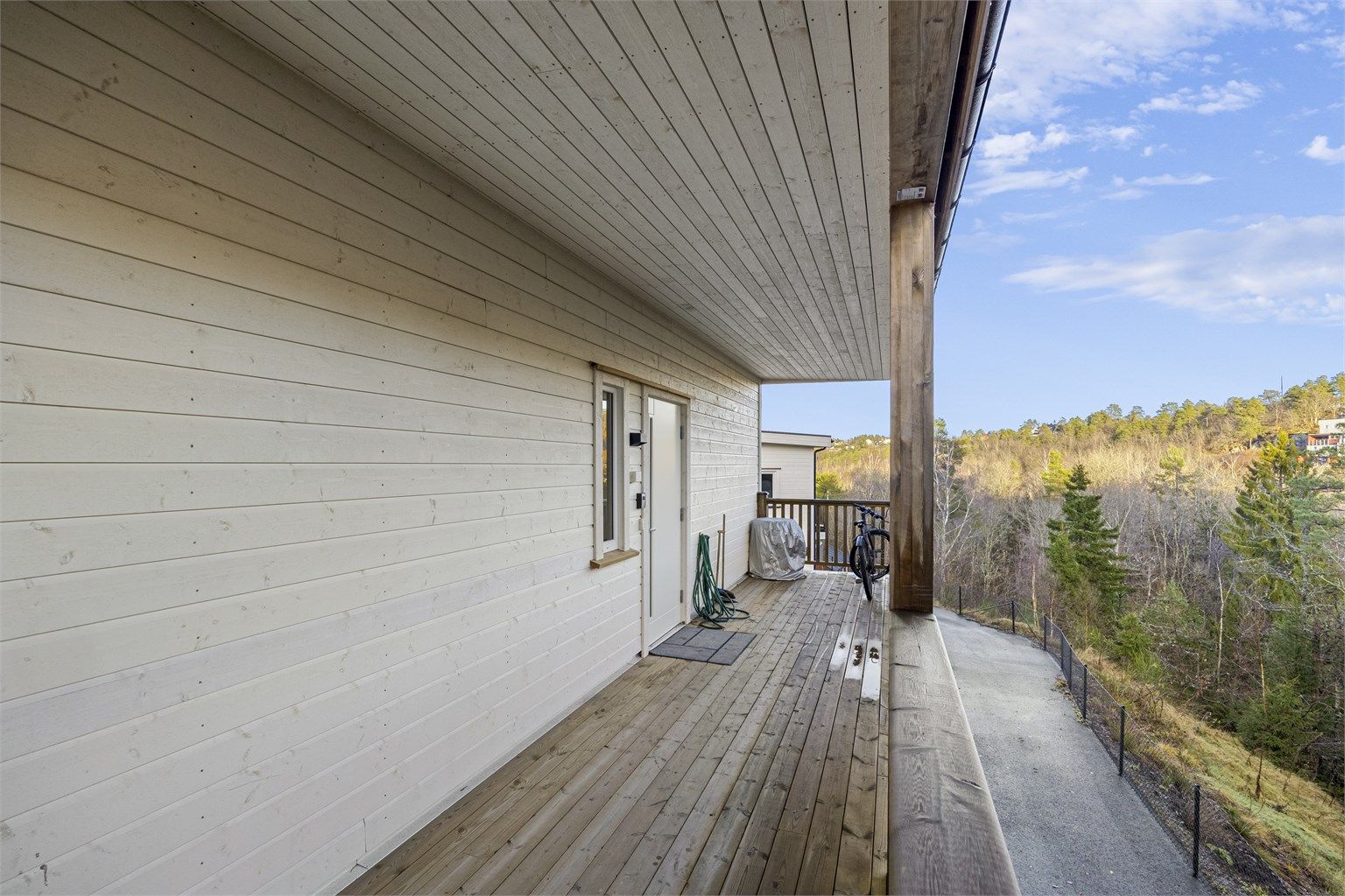 Inngangsparti med takoverbygg, perfekt ved regnværsdager eller for lettere å holde unna snøen. Det er flott skog bak eiendommen.