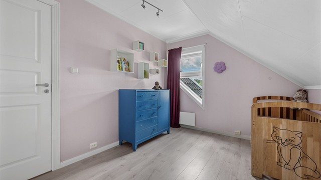 Soverom på loftet med laminatgulv og plass til seng og oppbevaring.