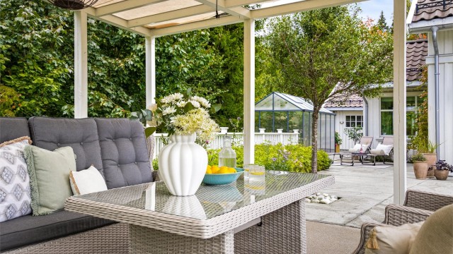 Fra uteplassen har man utsyn mot bl.a. hagen og drivhuset.