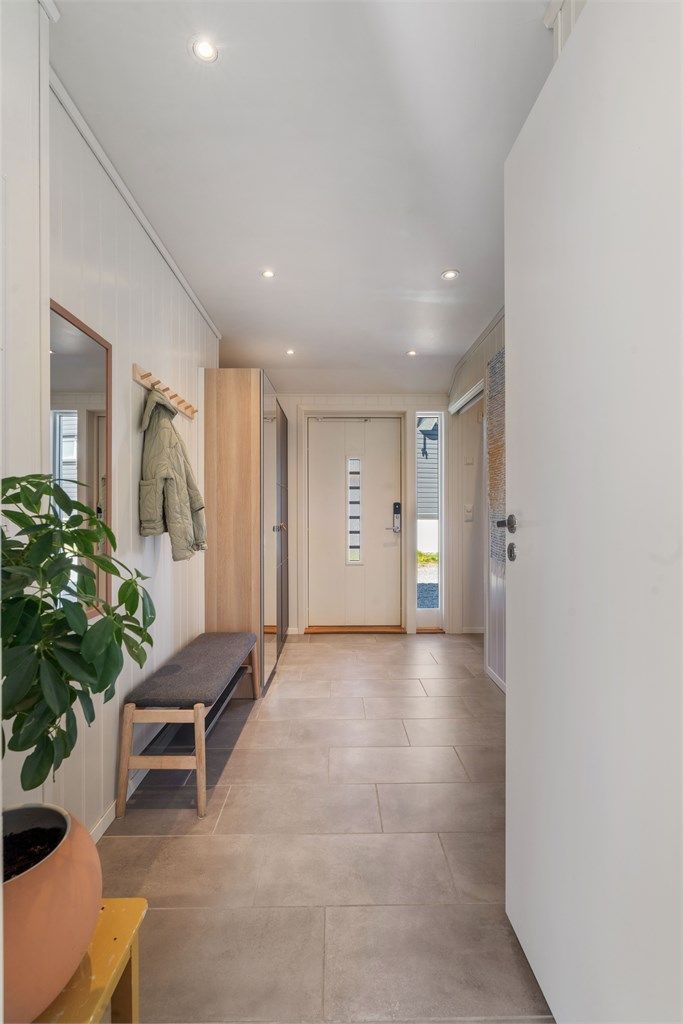 Velkommen inn her i Hauabakkvegen 25. Der møter du først en romslig entrè, flisebelagt med varme i gulvet. Det er også god plass for garderobeløsninger til sko og klær.

Innvendig foto: Martin Nordbø